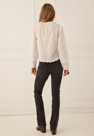  standing against a white paneled wall.